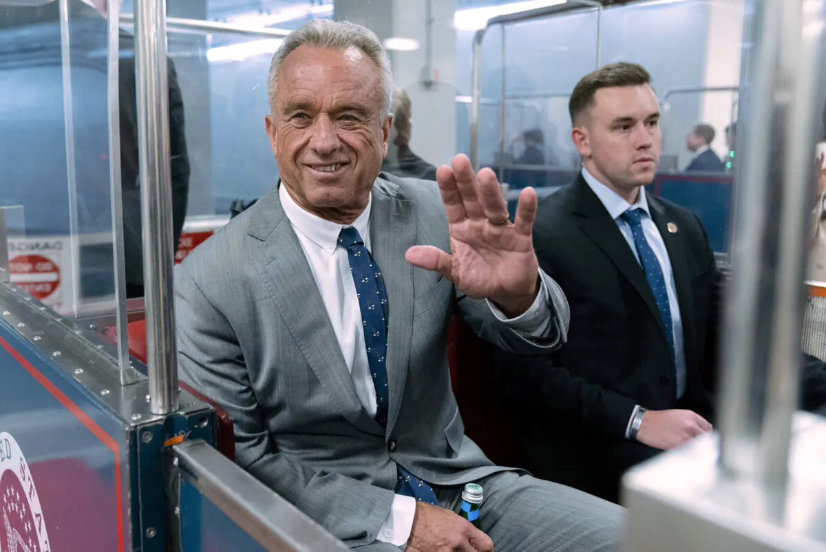 Robert F. Kennedy Jr. waves to reporters as he rides the train to a meeting with Sen. John Thune (R-S.D.) at the Capitol on Dec. 17, 2024. (AP Photo/Jose Luis Magana, File)