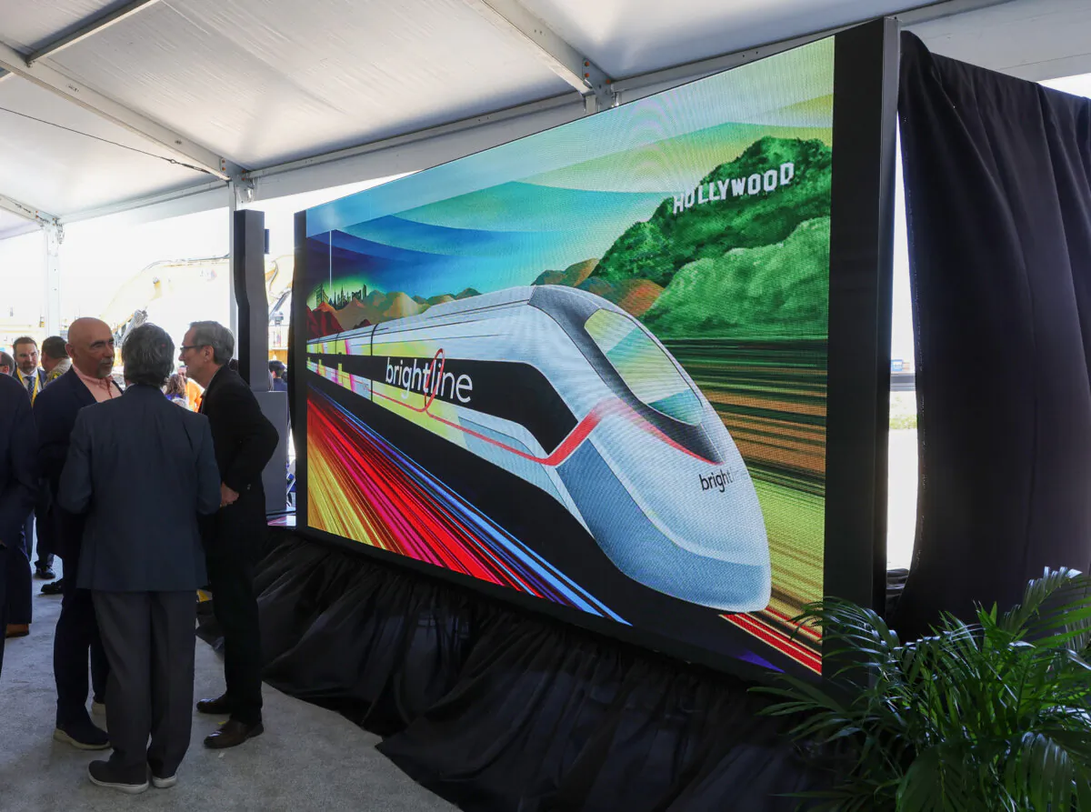 Attendees talk as a monitor displays a Brightline West presentation after a ceremony at the Brightline West Las Vegas station in Las Vegas, Nevada, on April 22, 2024. (Ethan Miller/Getty Images)