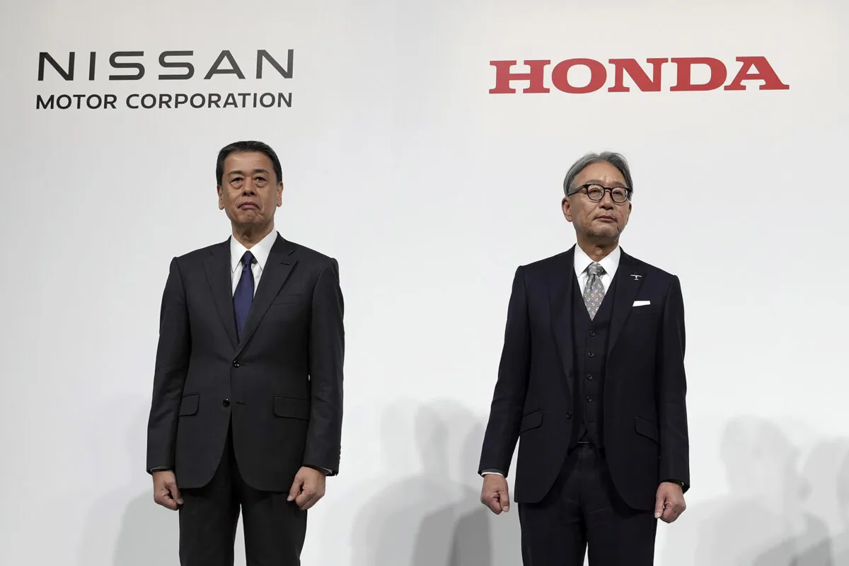 Nissan Chief Executive Makoto Uchida (L) and Honda Chief Executive Toshihiro Mibe (R) pose for photographers during a joint news conference in Tokyo on Dec. 23, 2024. (Eugene Hoshiko/AP Photo)