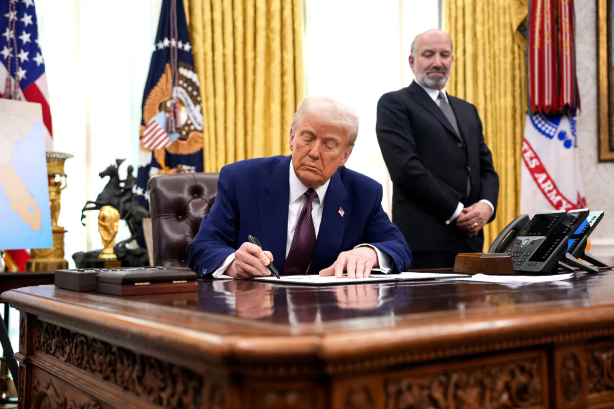 President Donald Trump, joined by Secretary of Commerce Howard Lutnick, signs an executive order on reciprocal tariffs in the Oval Office at the White House on Feb. 13, 2025. (Andrew Harnik/Getty Images)