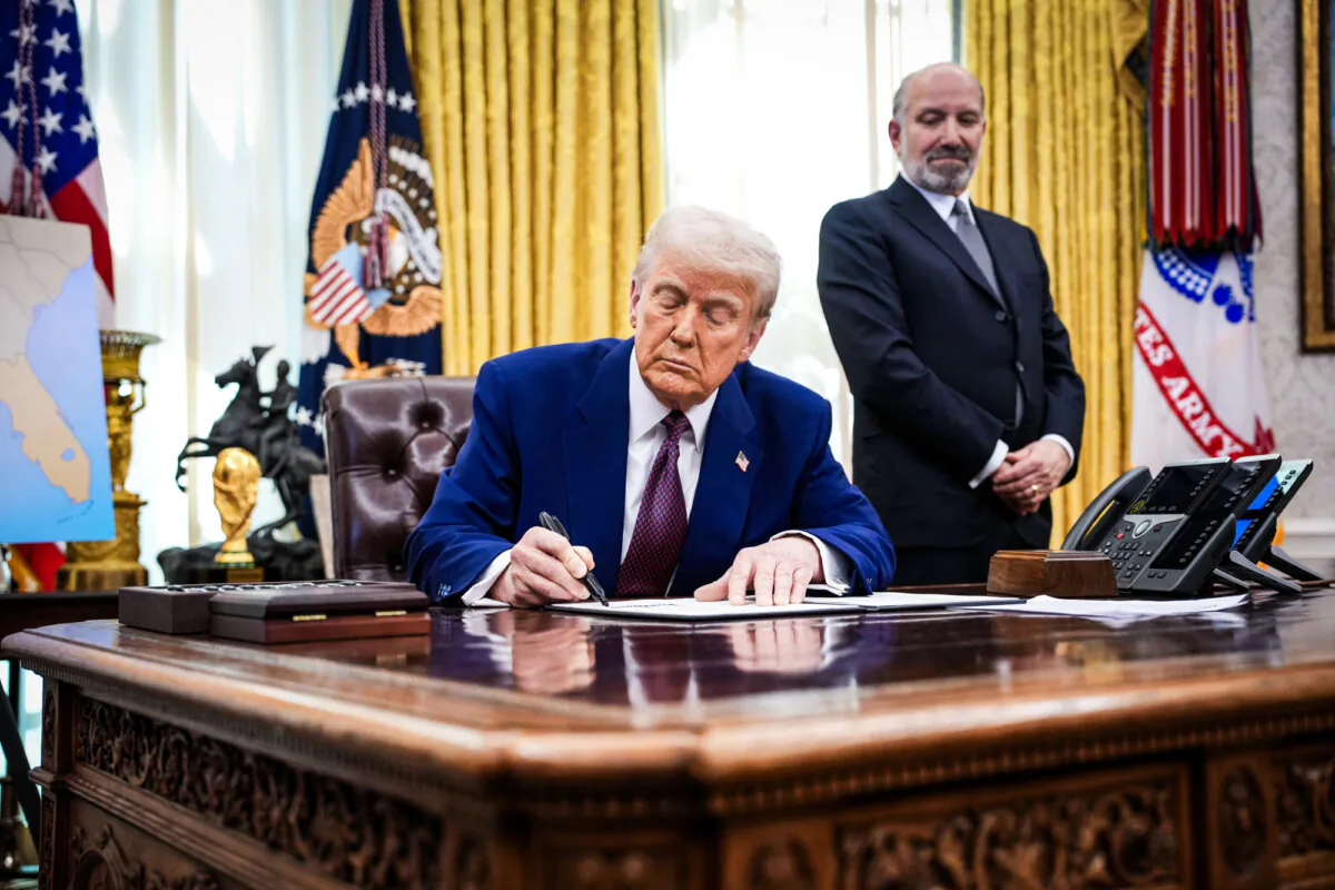 President Donald Trump, joined by Secretary of Commerce nominee Howard Lutnick, signs an executive order on reciprocal tariffs in the Oval Office on Feb. 13, 2025. (Andrew Harnik/Getty Images)