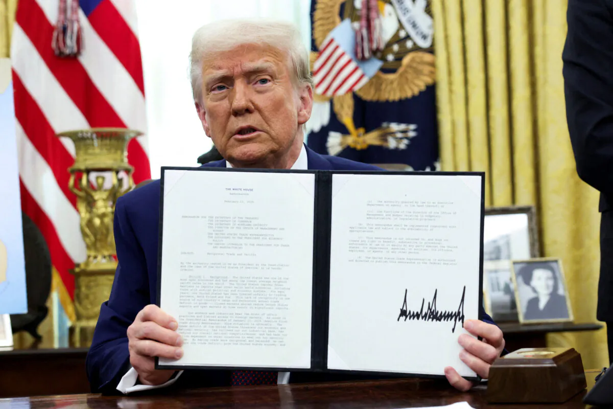 President Donald Trump holds an executive order on tariff increases in the Oval Office on Feb. 13, 2025. (Kevin Lamarque/Reuters)