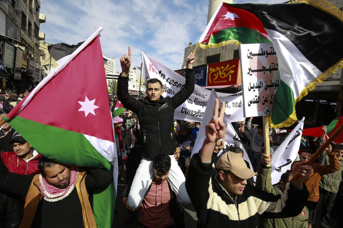 People carry flags and banners as they protest against President Donald Trump's proposal for the United States to take over the Gaza Strip and to move more than 2 million Palestinians out of the territory, in Amman, Jordan, on Feb. 14, 2025. (Khalil Mazraawi/AFP via Getty Images)