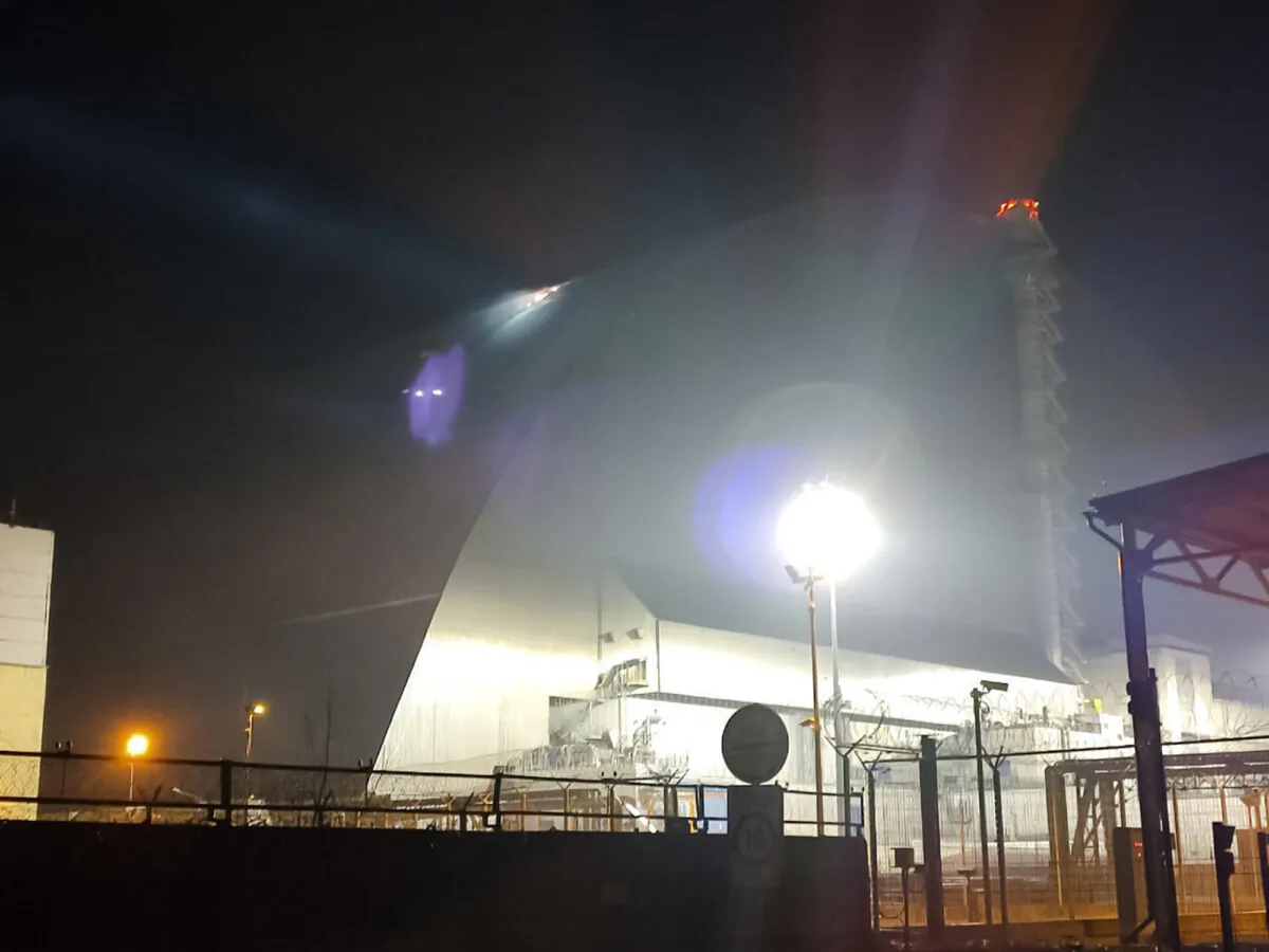 A searchlight illuminates a hole in the roof—said to have been caused by a Russian drone—of the damaged sarcophagus that covers the destroyed fourth reactor of Chernobyl nuclear power plant in Chernobyl, Ukraine, on Feb. 14, 2025. (Ukrainian Emergency Service via AP)