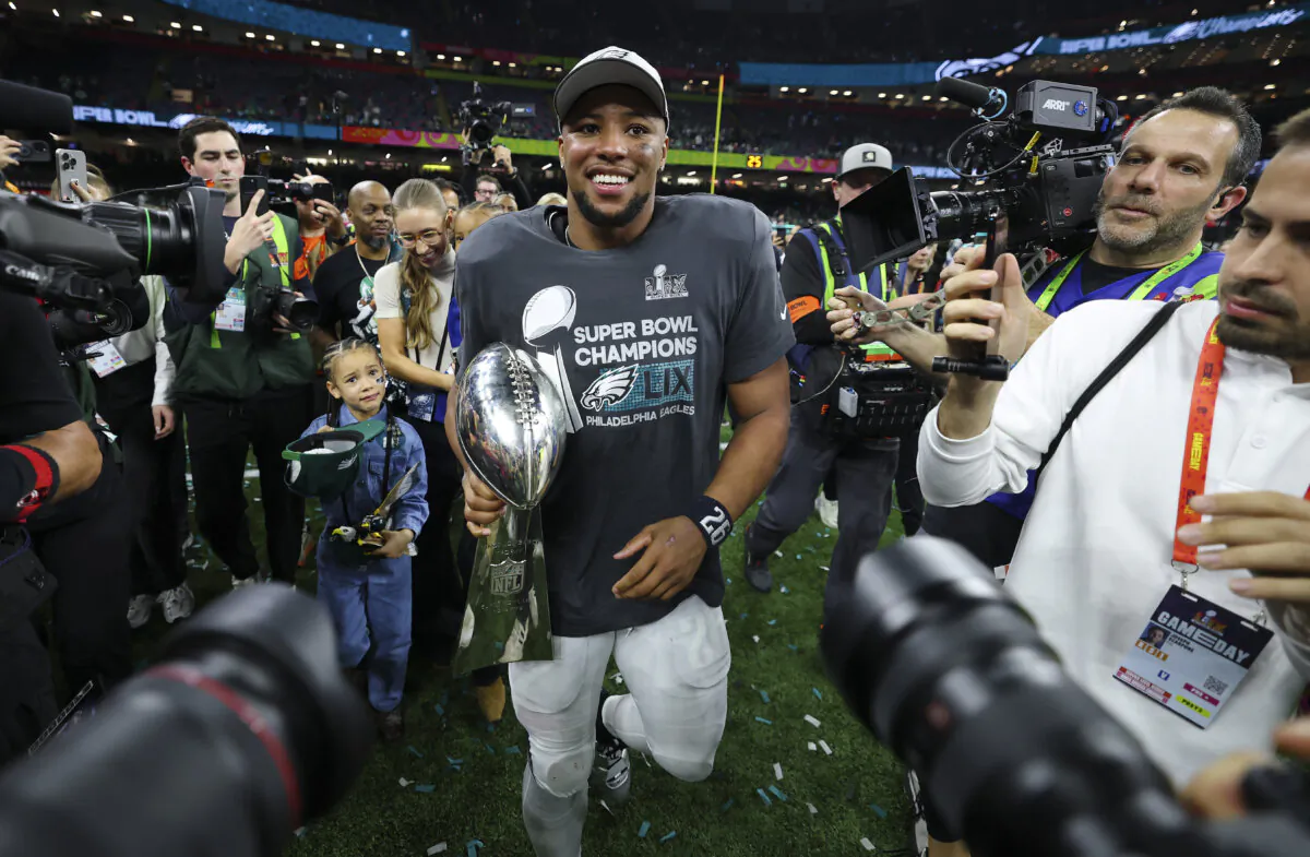 Saquon Barkley (26) of the Philadelphia Eagles celebrates with the Vince Lombardi Trophy after beating the Kansas City Chiefs 40–22 to win Super Bowl LIX at Caesars Superdome in New Orleans, Louisiana, on Feb. 9, 2025. (Gregory Shamus/Getty Images)