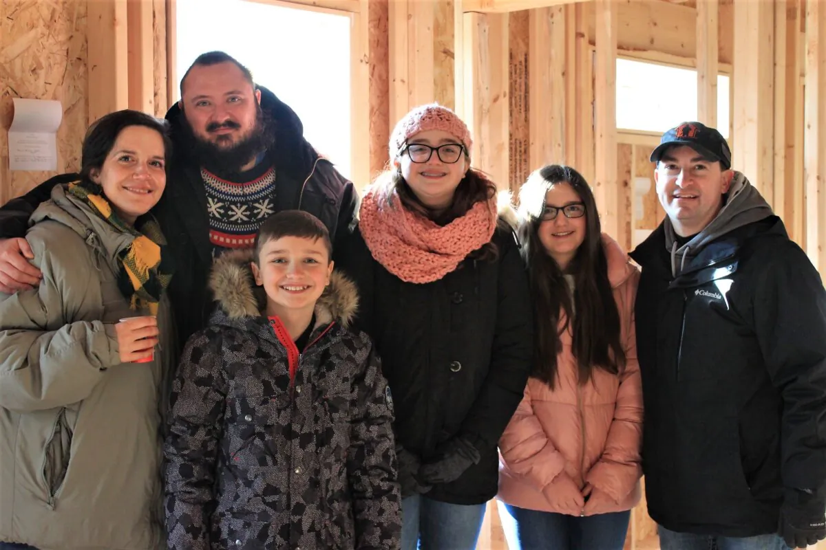 Tyson Cole, an injured veteran, and his family, pictured with David Belman (R), who helped build an adaptive home to accommodate the veteran's needs. (Courtesy of Operation Finally Home)