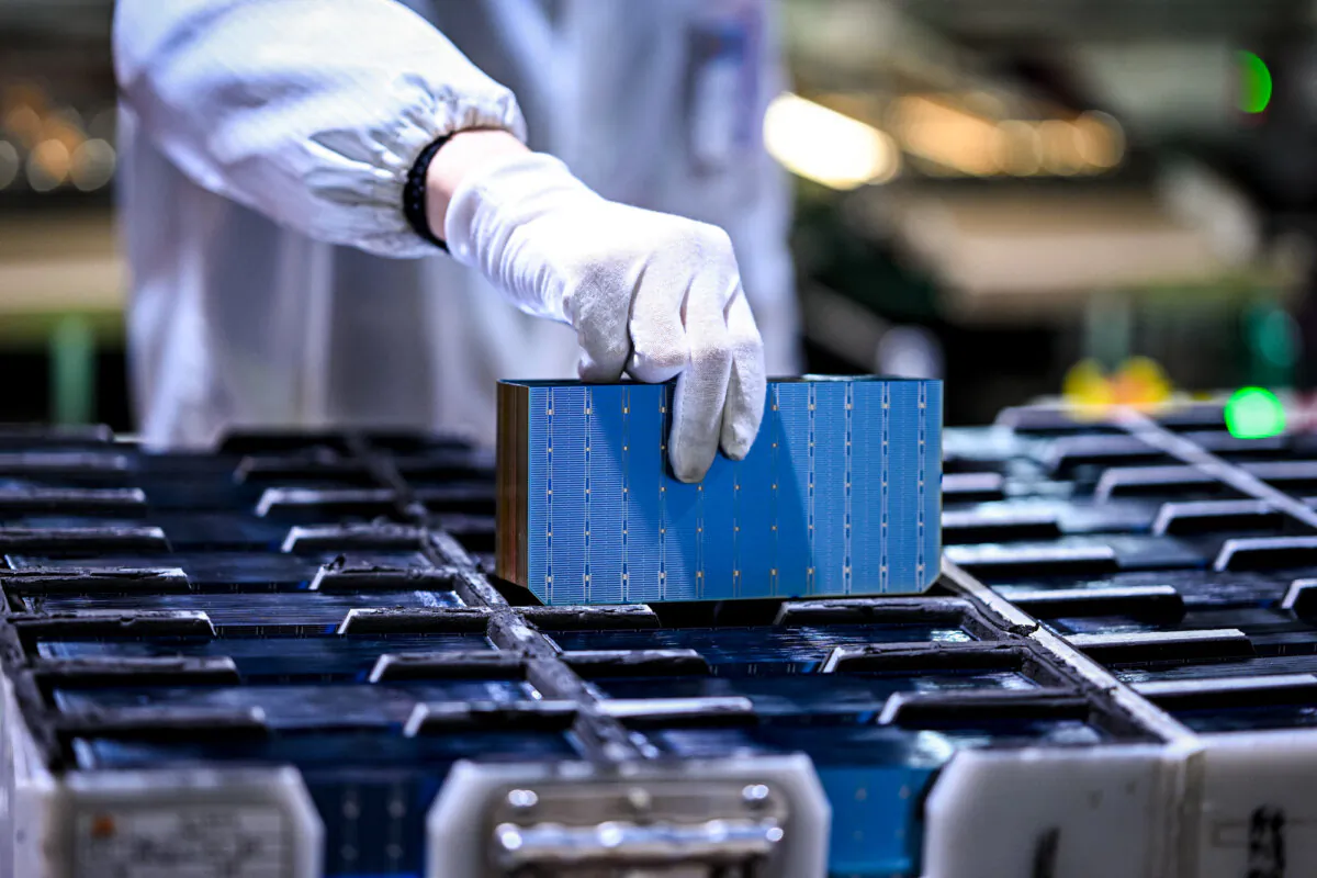 A worker holds a part of photovoltaic modules for solar panels in a factory in Suqian, Jiangsu Province, China, on Jan. 23, 2025. (STR/AFP via Getty Images)