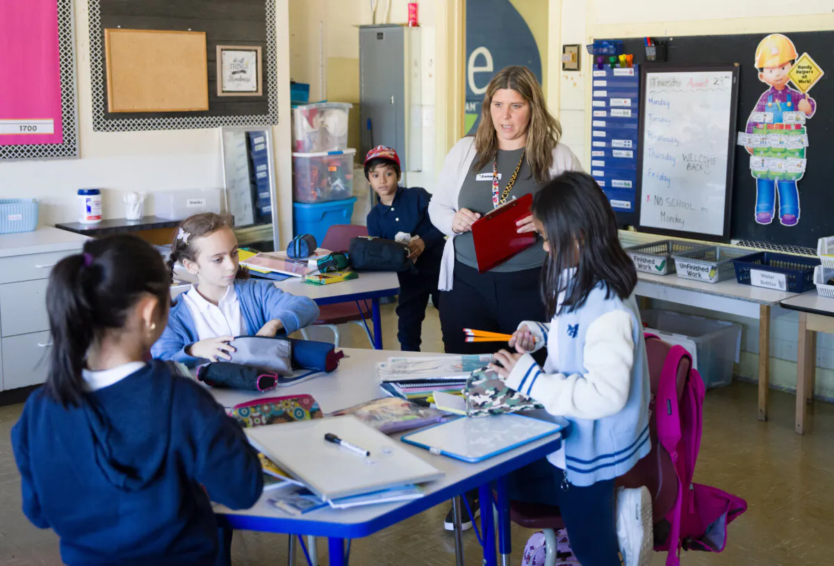 A teacher talks with her Grade 3 and 4 students on their first day back after summer break at an elementary school in Montreal on Aug. 29, 2024. (The Canadian Press/Christinne Muschi)