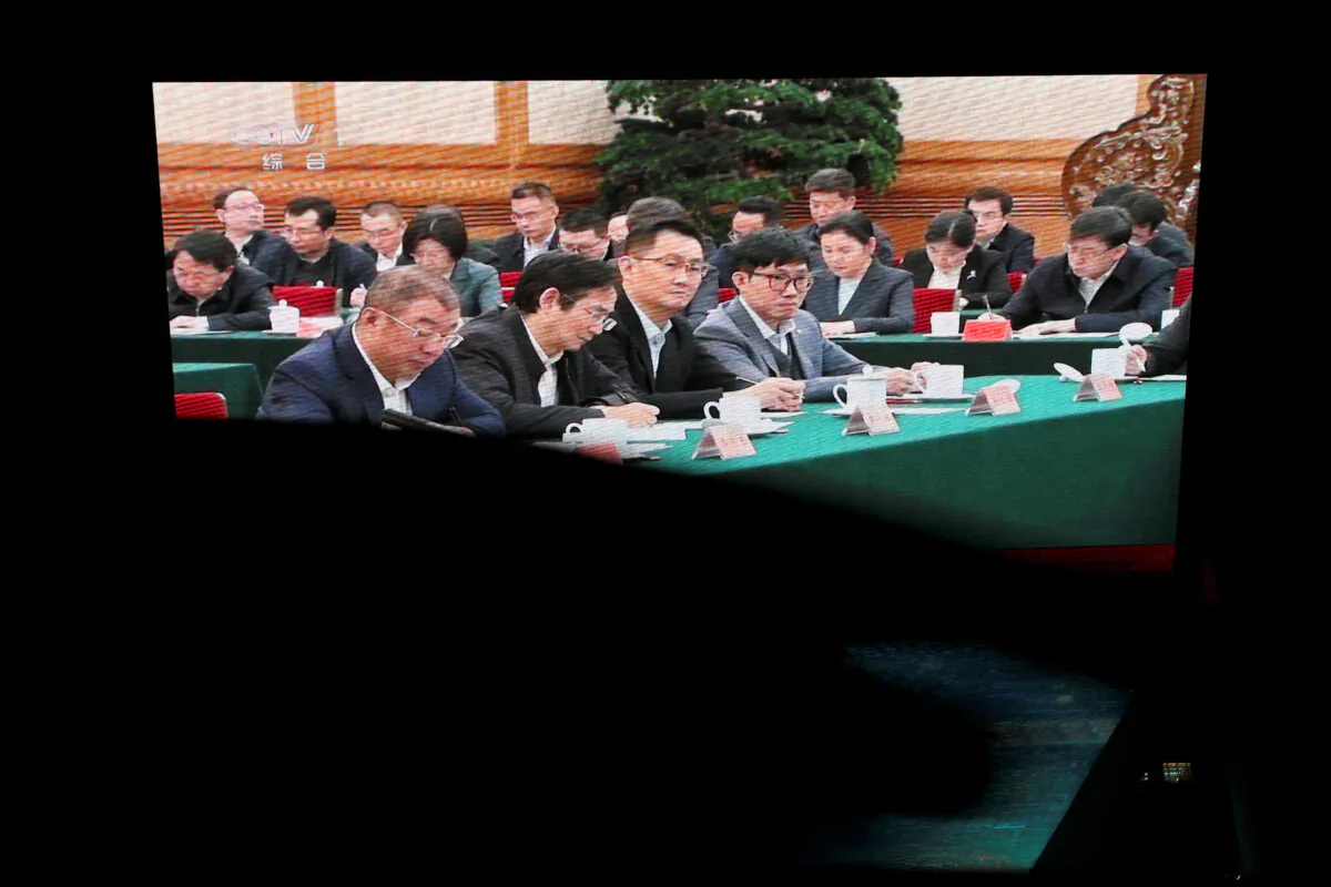 A giant screen shows news footage of Deepseek founder Liang Wenfeng and Tencent's Pony Ma attending a symposium on private enterprises, at a shopping complex in Beijing on Feb. 17, 2025. (Florence Lo/Reuters)