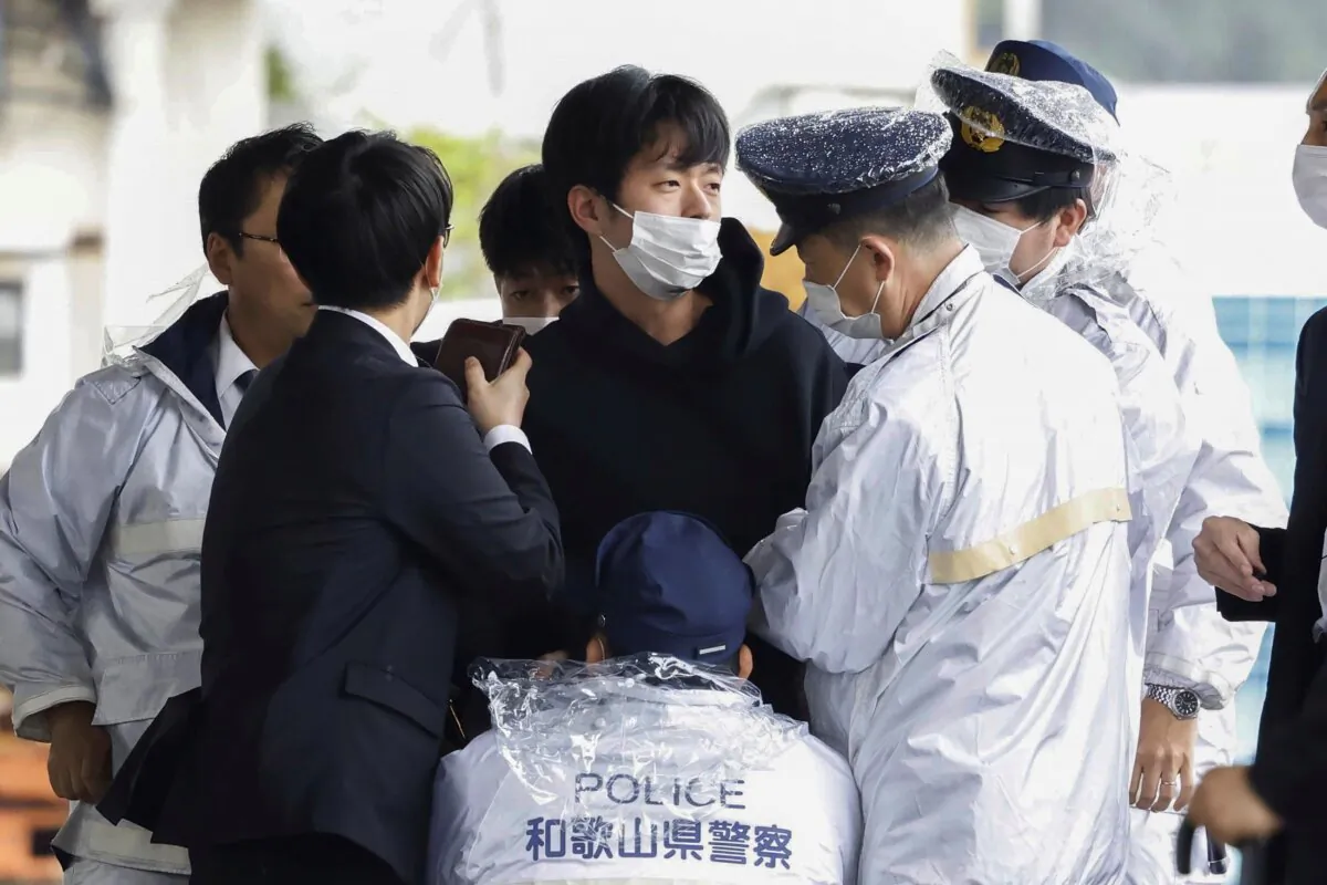 Ryuji Kimura (C), is caught by police after he threw a homemade pipe bomb at Japan's former Prime Minister Fumio Kishida during a campaign event in Wakayama, western Japan, on April 15, 2023. (Kyodo News via AP)