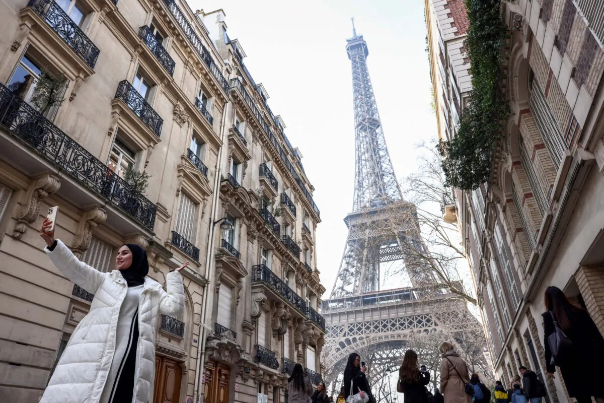 A tourist takes a selfie with the landmark Eiffel Tower in Paris on Feb. 19, 2025. (Behrouz Mehri/AFP via Getty Images)