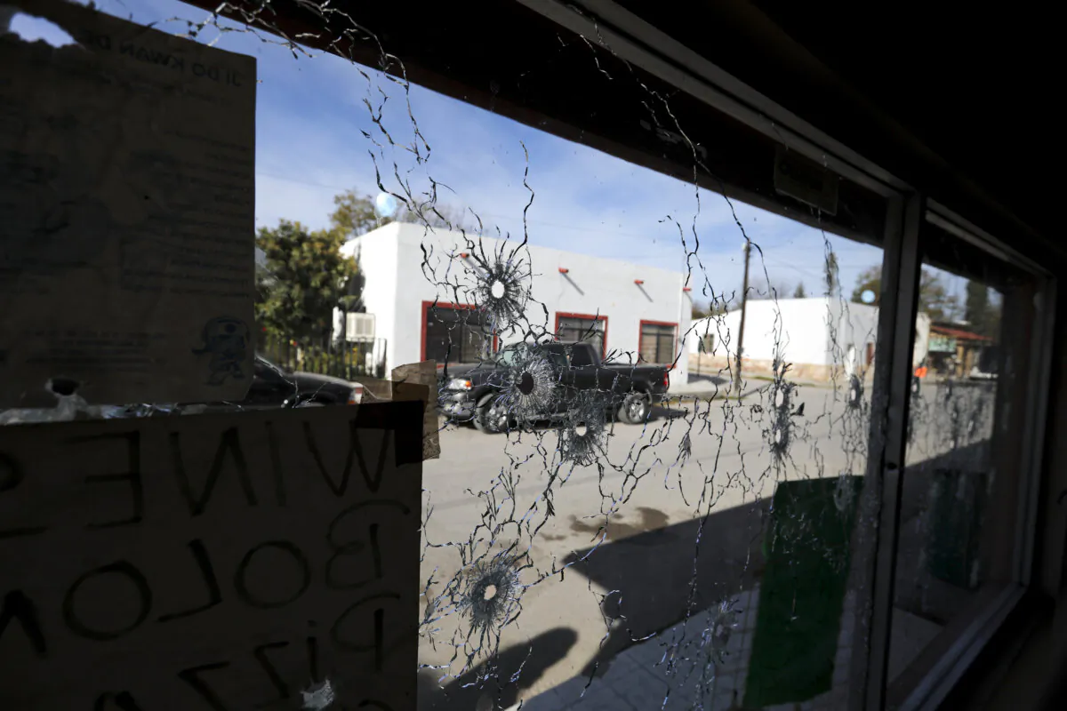 A shop's windows are riddled with bullets near City Hall after a gun battle between a heavily armed drug cartel assault group and security forces in Villa Union, Mexico, near the border with the United States, on Dec. 2, 2019. (Eduardo Verdugo/AP Photo)