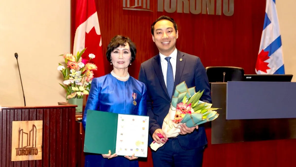 Canadian MP Kevin Vuong (R) presents a congratulatory letter to Tia Zhang, artist at Shen Yun Performing Arts and former instructor at Canada's National Ballet School, after awarding her with the King Charles III Coronation Medal, at Toronto City Hall on Feb. 13, 2025. (Xuewen Song)