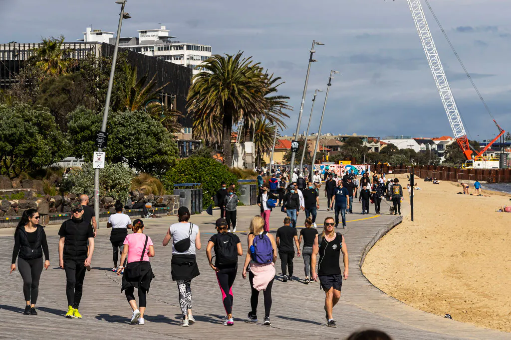 People walk along the seaside, inner-city suburb of St. Kilda in Melbourne, Australia on Oct. 2, 2021. (Daniel Pockett/Getty Images)
