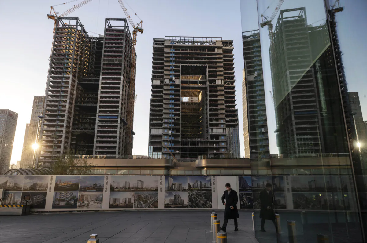 A man walks into an office building next to the site of new skyscrapers under construction in the Central Business District in Beijing on Nov. 29, 2024. (Kevin Frayer/Getty Images)