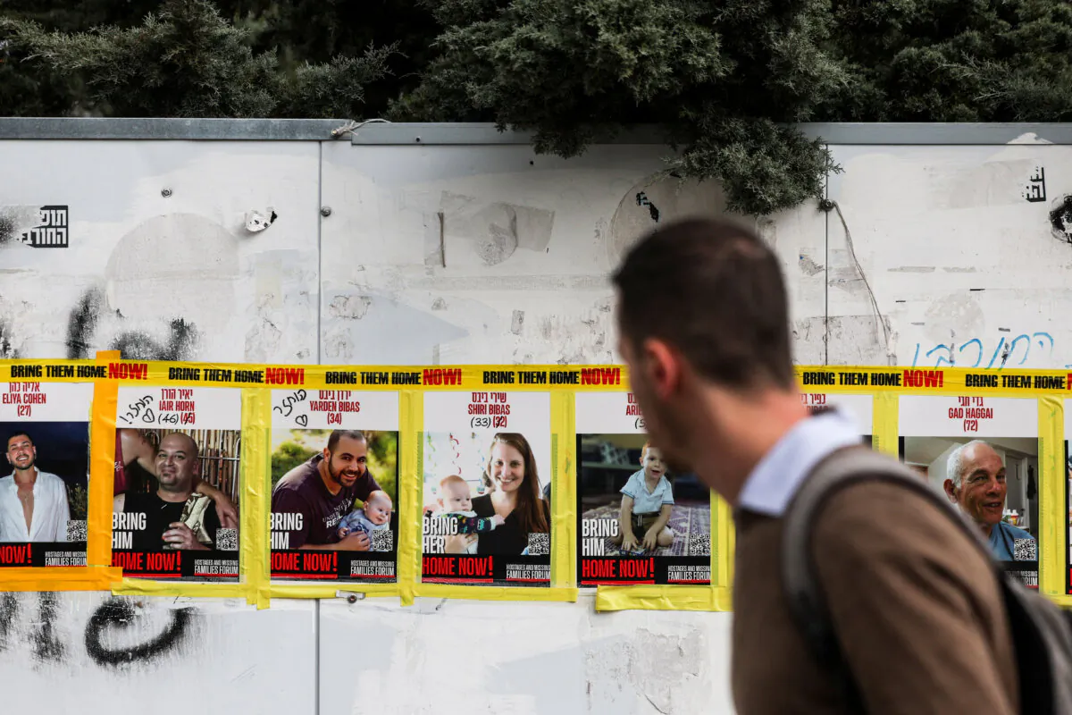 A man walks past pictures of Yarden Bibas, Shiri Bibas and Kfir Bibas in Jerusalem, Israel on Feb. 19, 2025. (Ronen Zvulun/Reuters)
