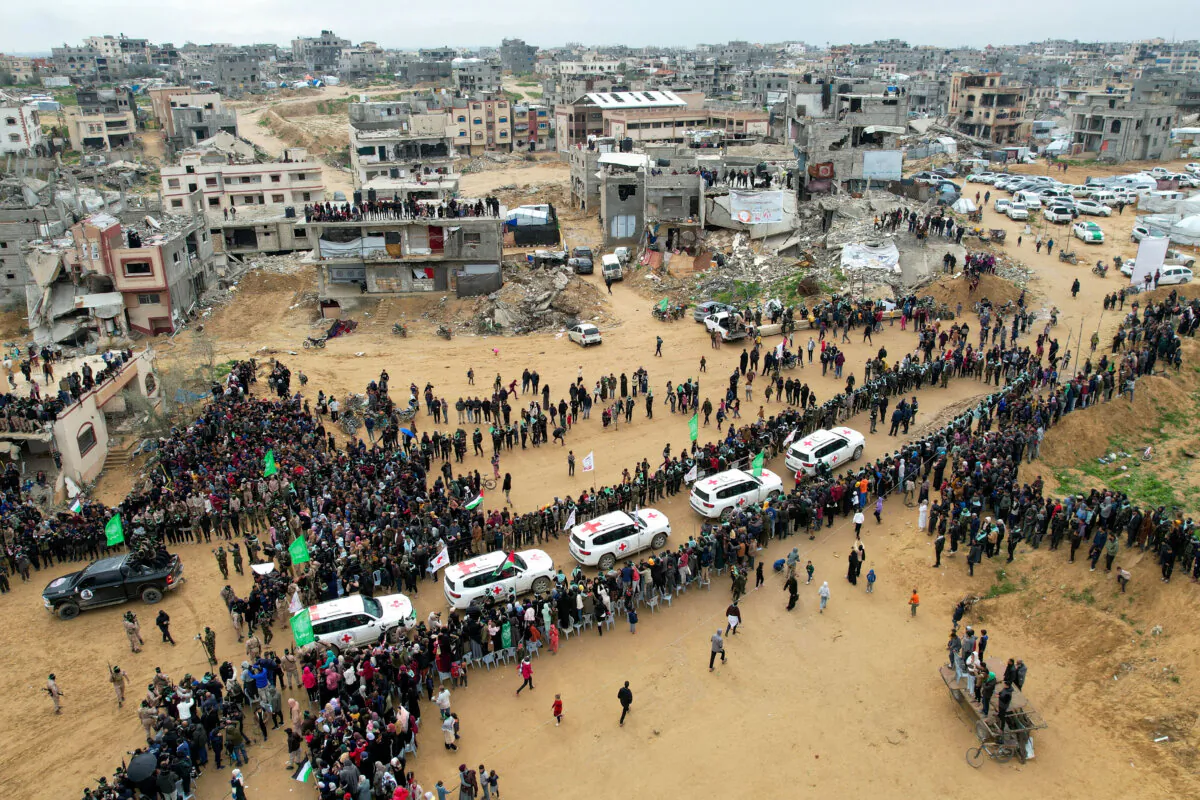 Palestinians and militants gather around Red Cross vehicles as Hamas hands over the bodies of deceased hostages Oded Lifschitz, Shiri Bibas and her two children Kfir and Ariel Bibas, seized during the deadly Oct. 7, 2023 attack, as part of a ceasefire and hostages-prisoners swap deal between Hamas and Israel, in Khan Younis in the southern Gaza Strip, on Feb. 20, 2025. (Stringer/Reuters)