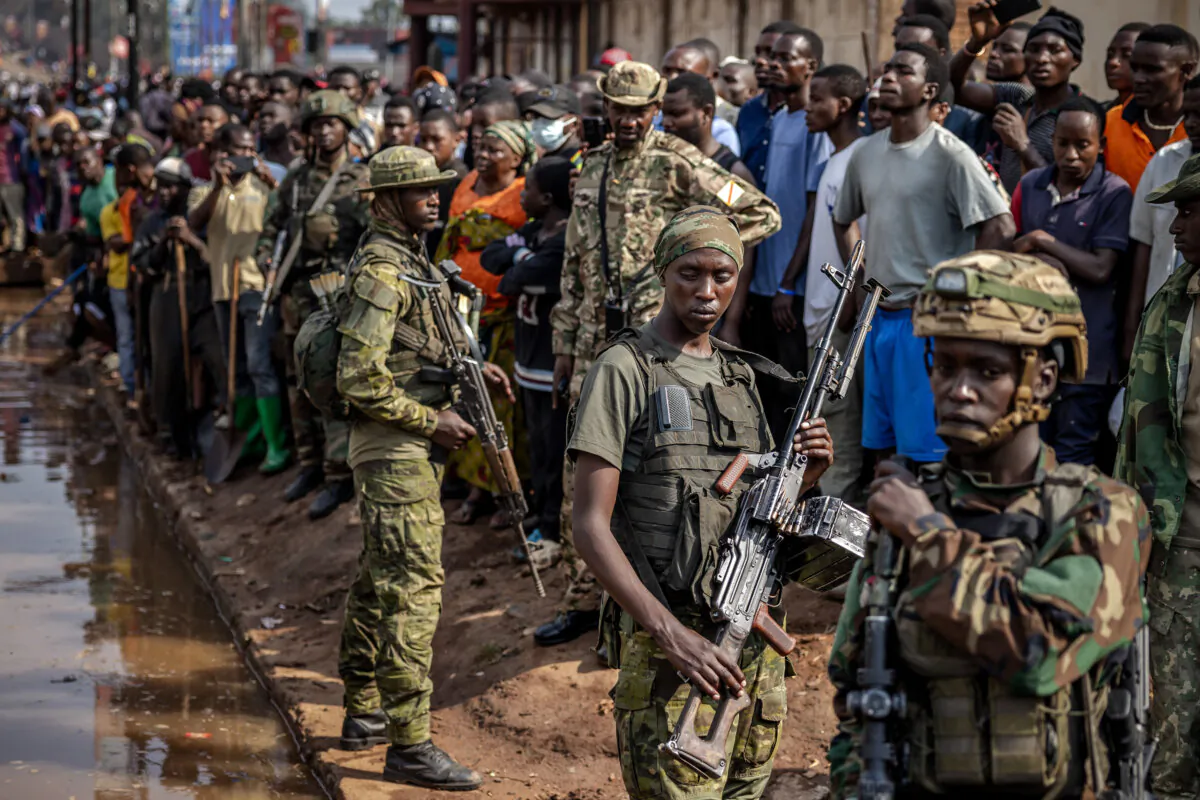M23 rebels monitor the area next to residents in Bukavu, Congo, on Feb. 20, 2025. (Luis Tato / AFP via Getty Images)