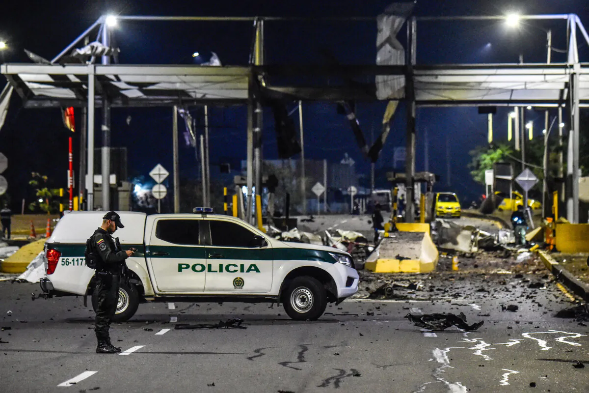 A police officer stands guard next to debris of a toll station attacked with explosives in Villa del Rosario, Norte de Santander province, Colombia, on February 20, 2025. Four bomb attacks, including one with a car bomb, were carried out in two Colombian cities bordering Venezuela, possibly by ELN guerrillas, officials said. (Schneyder Mendoza/AFP via Getty Images)
