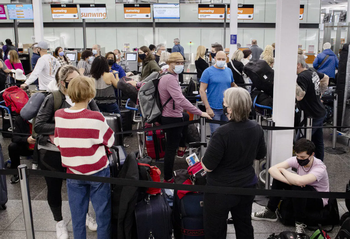 Travellers wait in line at a Sunwing Airlines check-in desk at Trudeau Airport in Montreal, on April 20, 2022. (The Canadian Press/Graham Hughes)