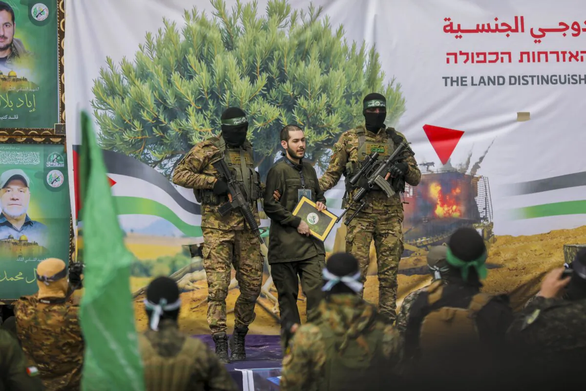 Hamas terrorists accompany Israeli hostage Eliya Cohen to be handed over to the Red Cross in Nuseirat in the central Gaza Strip, after his release as part of the seventh hostage-prisoner exchange on Feb. 22, 2025. (Youssef Alzanoun/Middle East Images via AFP via Getty Images)