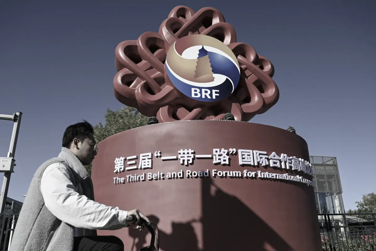 A man rides a bike past an installation of the logo of the Belt and Road Forum along a street in Beijing on Oct. 15, 2023. (Jade Gao/AFP via Getty Images)
