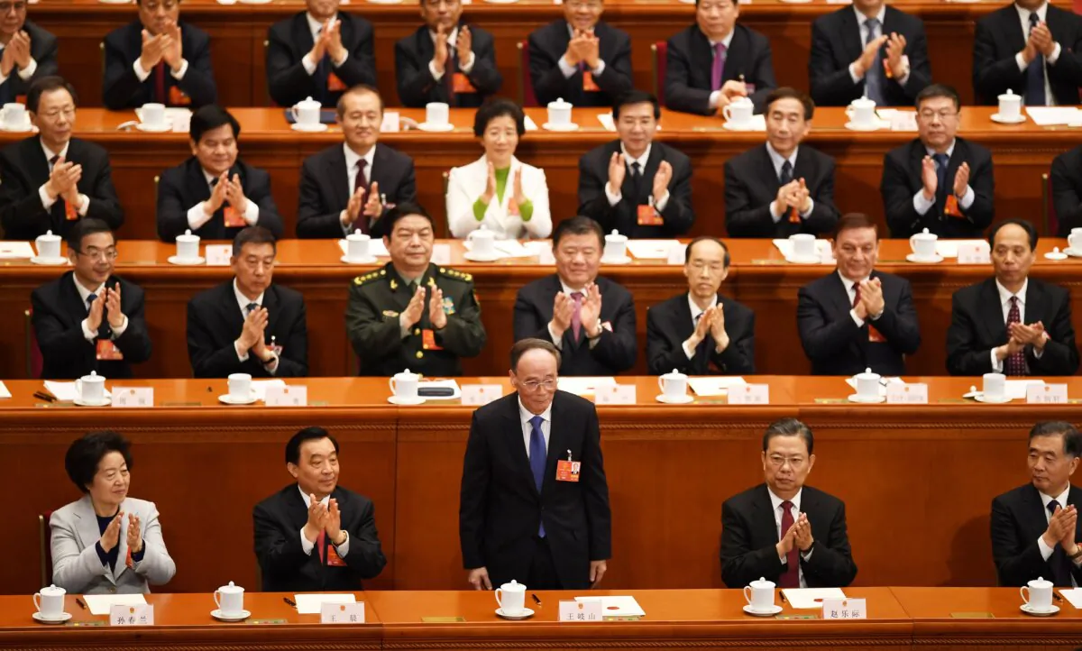 Wang Qishan (C), China's newly elected Vice President, receives applause after being elected during the fifth plenary session of the first session of the 13th National People's Congress (NPC) at the Great Hall of the People in Beijing on March 17, 2018. (GREG BAKER/AFP via Getty Images)