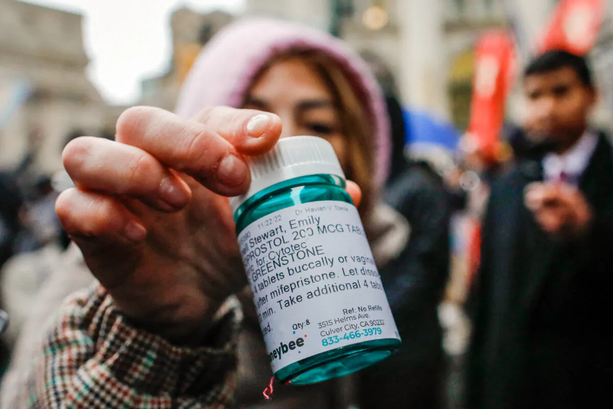 A pro-abortion activist shows a bottle of abortion pills at a counterprotest to a pro-life demonstration in New York City on March 25, 2023. (Kena Betancur/AFP via Getty Images)
