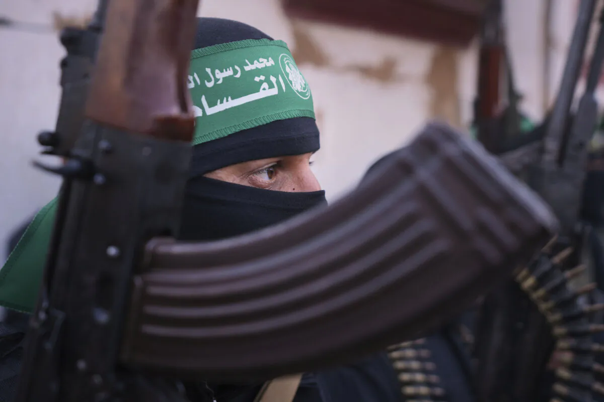 A member of the Islamic Jihad group holds his weapon as Israeli hostages are escorted to be handed over to the Red Cross in Khan Younis, southern Gaza Strip, on Jan. 30, 2025. (AP Photo/Abdel Kareem Hana)