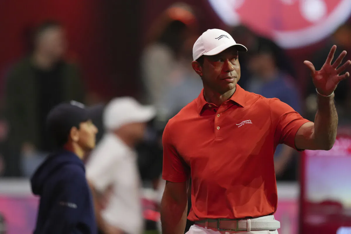 Tiger Woods waves to fans as he is introduced before a match of the TMRW Golf League against Boston Common Golf in Palm Beach Gardens, Fla., on Jan. 27. (Rebecca Blackwell/AP Photo)
