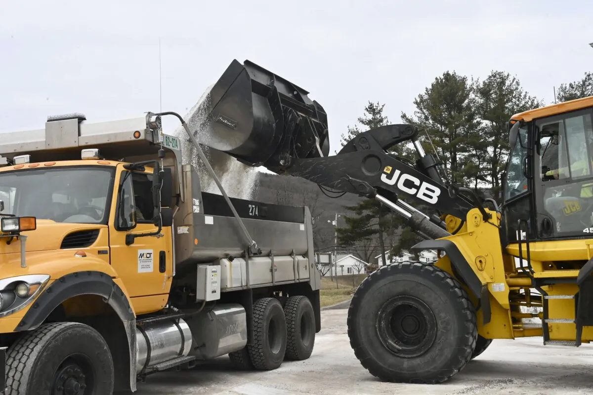 Maryland Department of Transportation employees use a backhoe to load a truck with salt at the State Highway Administration District 6 Office in LaVale, Md., on Feb. 5, 2025. (Steve Bittner/Cumberland Times-News via AP)