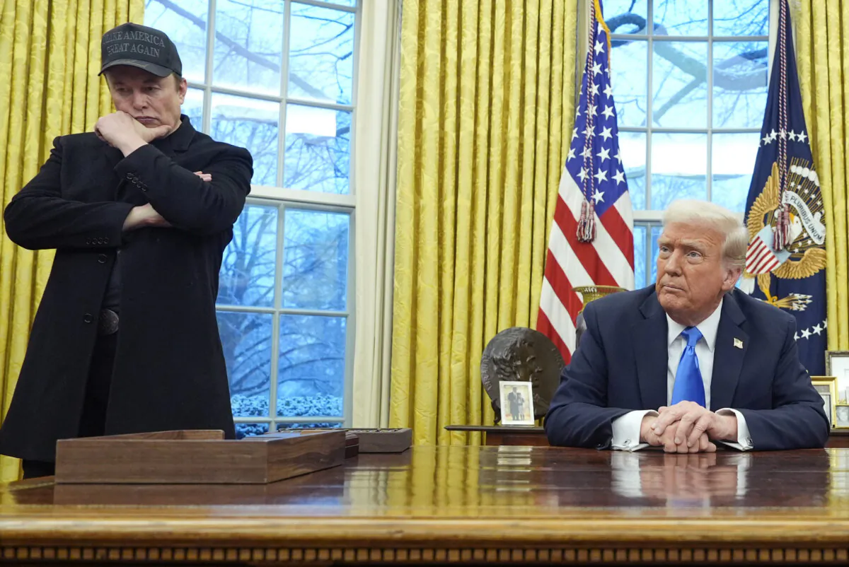 Elon Musk listens as President Donald Trump speaks with reporters in the Oval Office at the White House, on Feb. 11, 2025. (Alex Brandon/AP Photo)