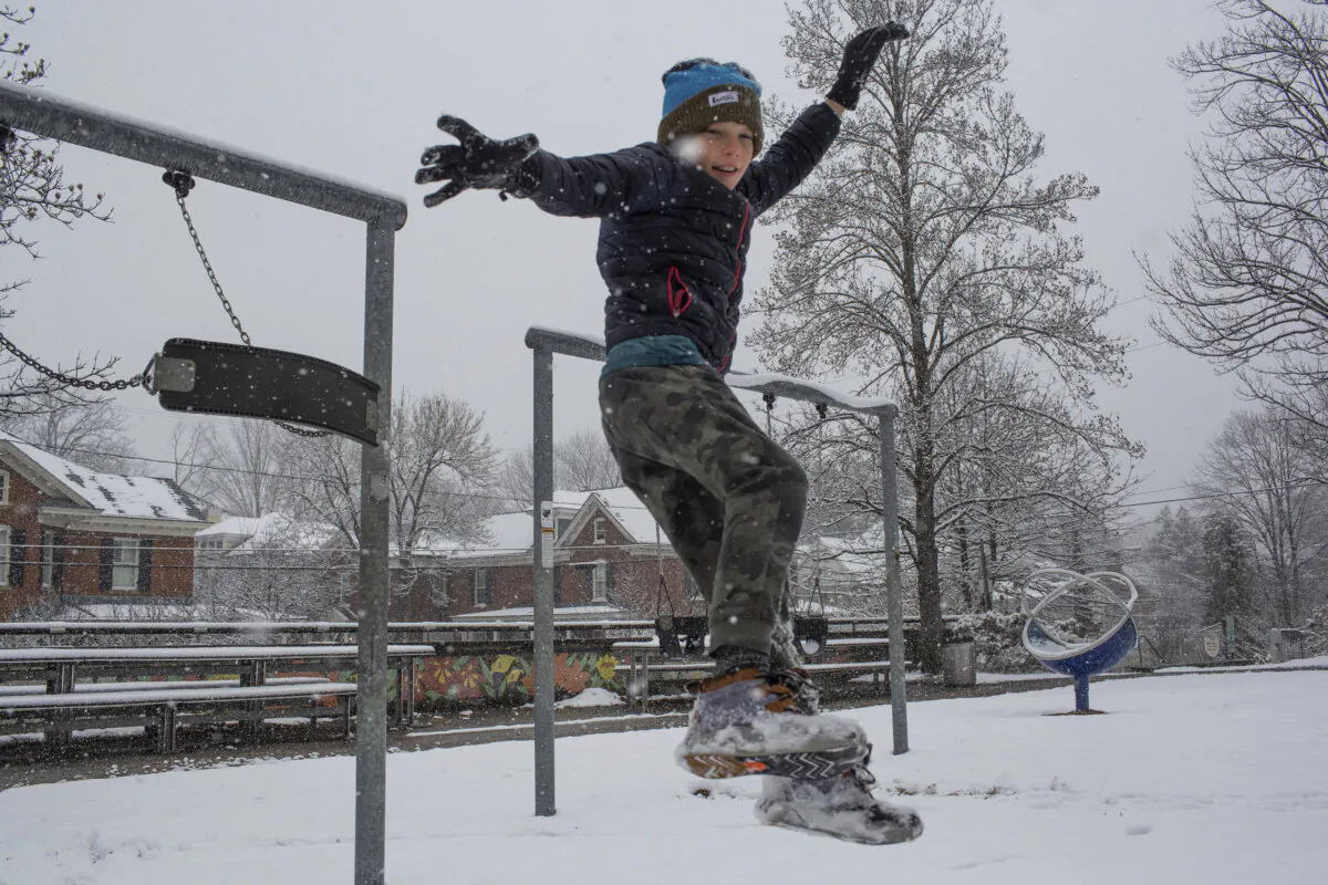 Will Bowles jumps off a swing set during a winter snowstorm in Charlottesville, Va., on Feb. 11, 2025. (Cal Cary/The Daily Progress via AP)