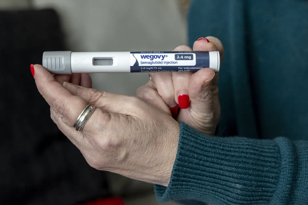 A woman holds up a dosage of Wegovy, a drug used for weight loss, at her home in Front Royal, Va., on March 1, 2024. (Amanda Andrade-Rhoades/AP)