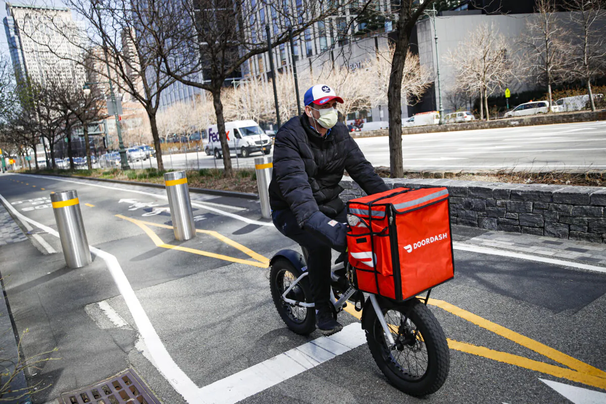 A delivery worker rides his bicycle along a path on the West Side Highway in New York on March 16, 2020. (AP Photo/John Minchillo, File)