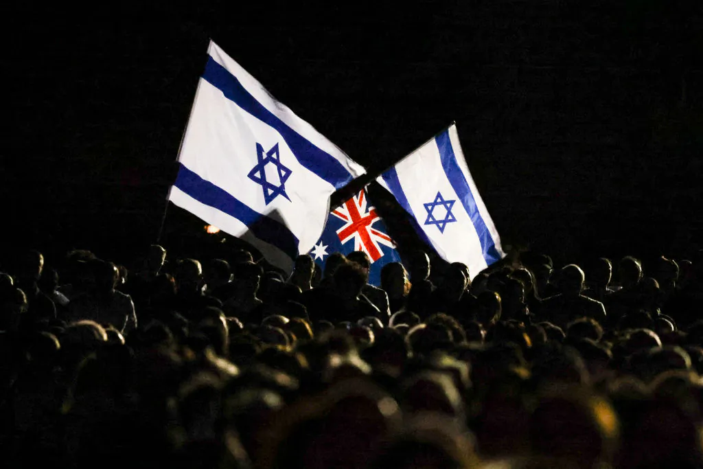 Members of the Australian Jewish community hold Israeli and Australian flags during a memorial service in Sydney, Australia on Oct. 7, 2024. (David Gray/AFP via Getty Images)