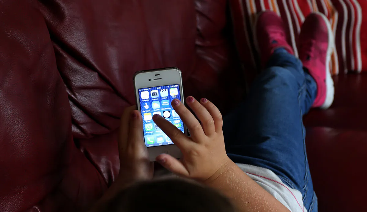 A photo of a child using an Apple iPhone smartphone on Aug. 21, 2014. (Peter Byrne/PA)