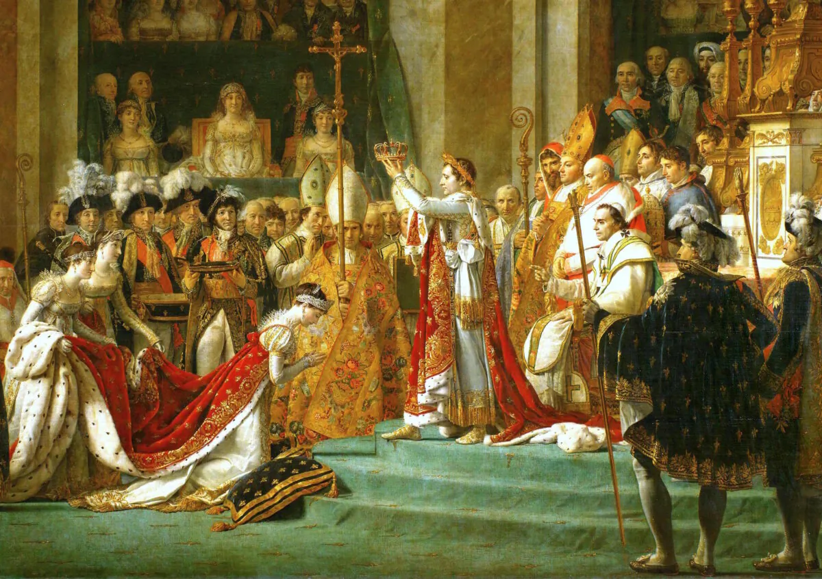 Josephine kneels before Napoleon as he is about to place the crown on her head during his coronation at Notre Dame. Behind him sits pope Pius VII. (Public Domain)