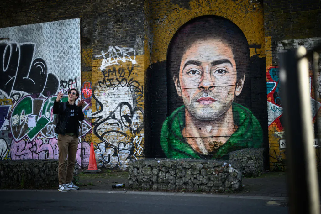 A man takes a selfie in front of a mural of Luigi Mangione, who is charged with killing the CEO of UnitedHealthcare in 2024 in New York City, in the Bethnal Green area of London on March 4, 2025. (Leon Neal/Getty Images)