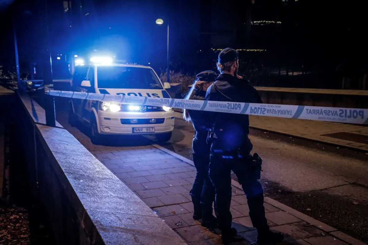 A police forensics team works on the site where the Swedish rapper Einar—real name Nils Kurt Erik Einar Gronberg—was shot dead in the street in the Hammarby Sjostad district of Stockholm on Oct. 21, 2021. (Christine Olsson/TT news agency/AFP via Getty Images)