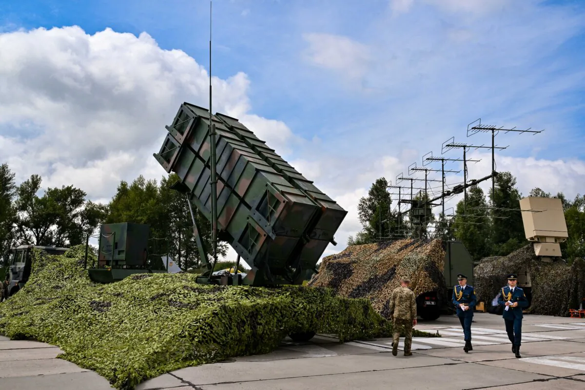 Ukrainian servicemen walk past a Patriot air defense system at an undisclosed area on Aug. 4, 2024. (Sergei Supinsky/AFP via Getty Images)