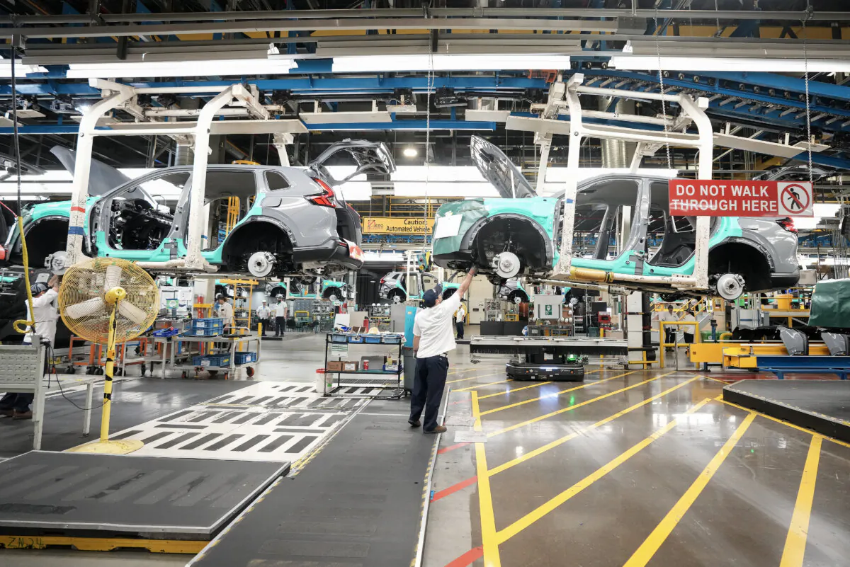 Honda employees work along the vehicle assembly line before an event announcing plans for a Honda electric vehicle battery plant in Alliston, Ont., on April 25, 2024. (The Canadian Press/Nathan Denette) 