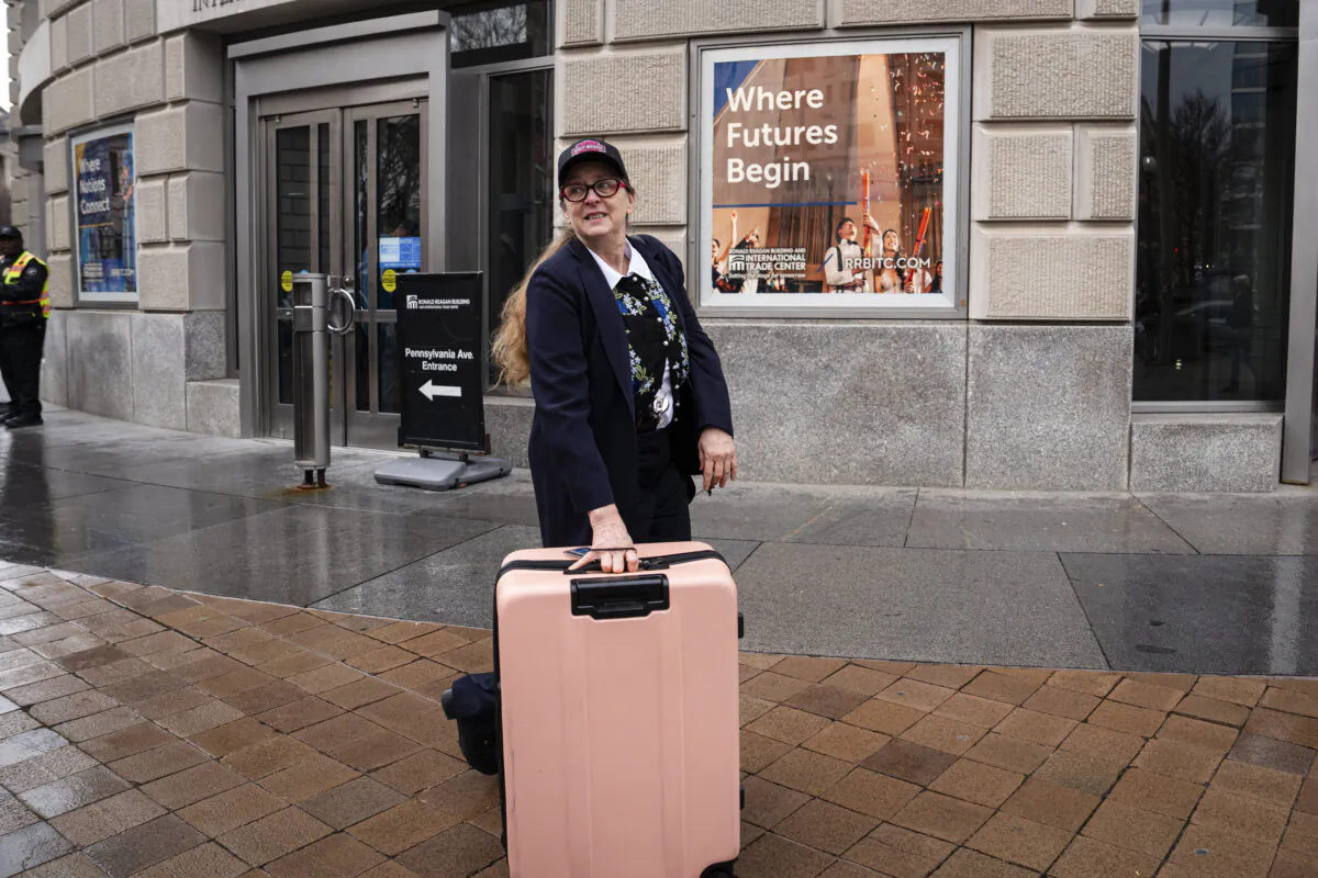 A USAID federal worker with her personal belongings leaves the USAID office in Washington on Feb. 27, 2025. (Madalina Vasiliu/The Epoch Times)