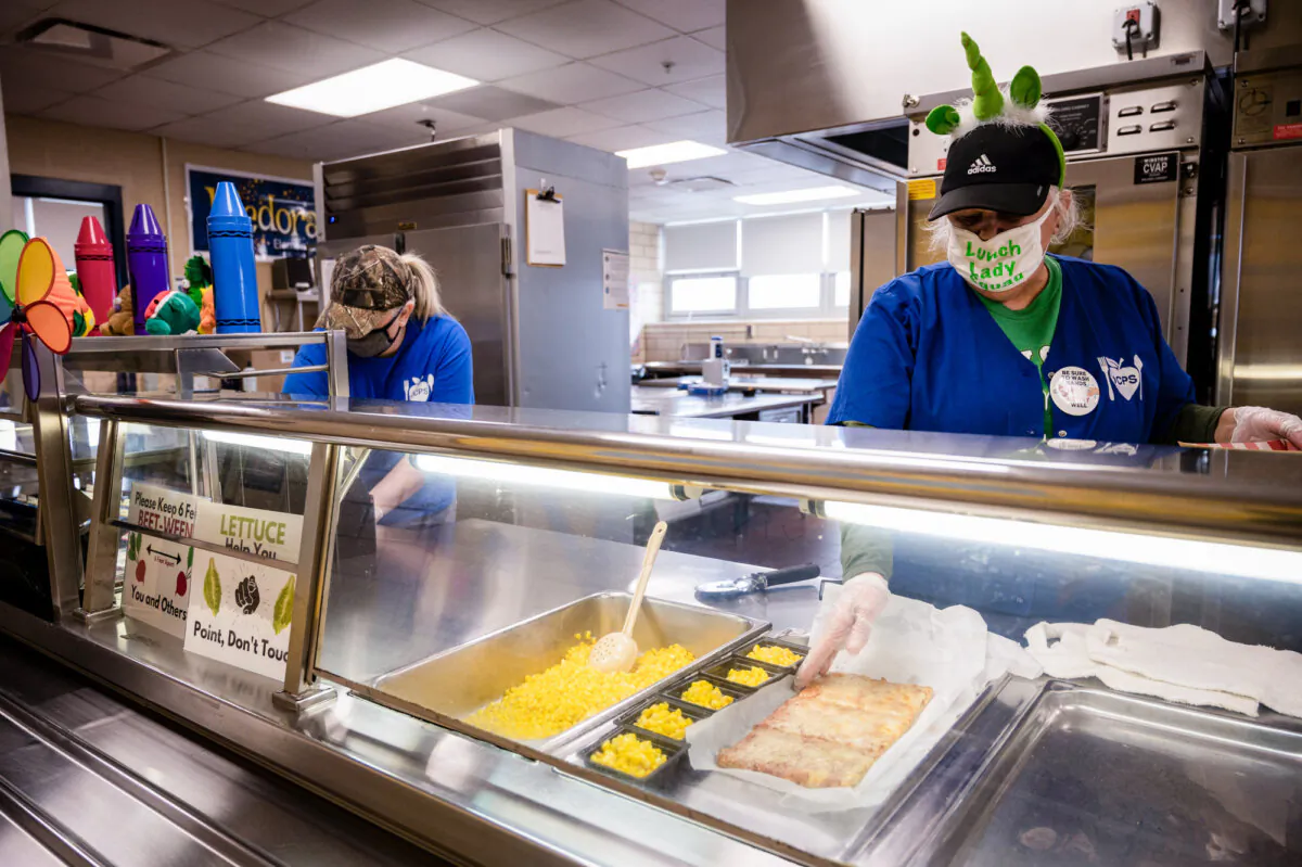 Cafeteria workers serve lunch at Medora Elementary School in Louisville, Ky., on March 17, 2021. (Jon Cherry/Getty Images)