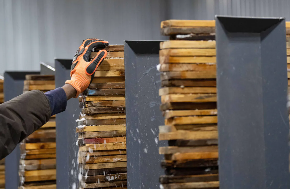 Workers stack and sort softwood lumber at Groupe Crete, a sawmill in Mont-Blanc, Que., on Jan. 20, 2025. (The Canadian Press/Christinne Muschi)