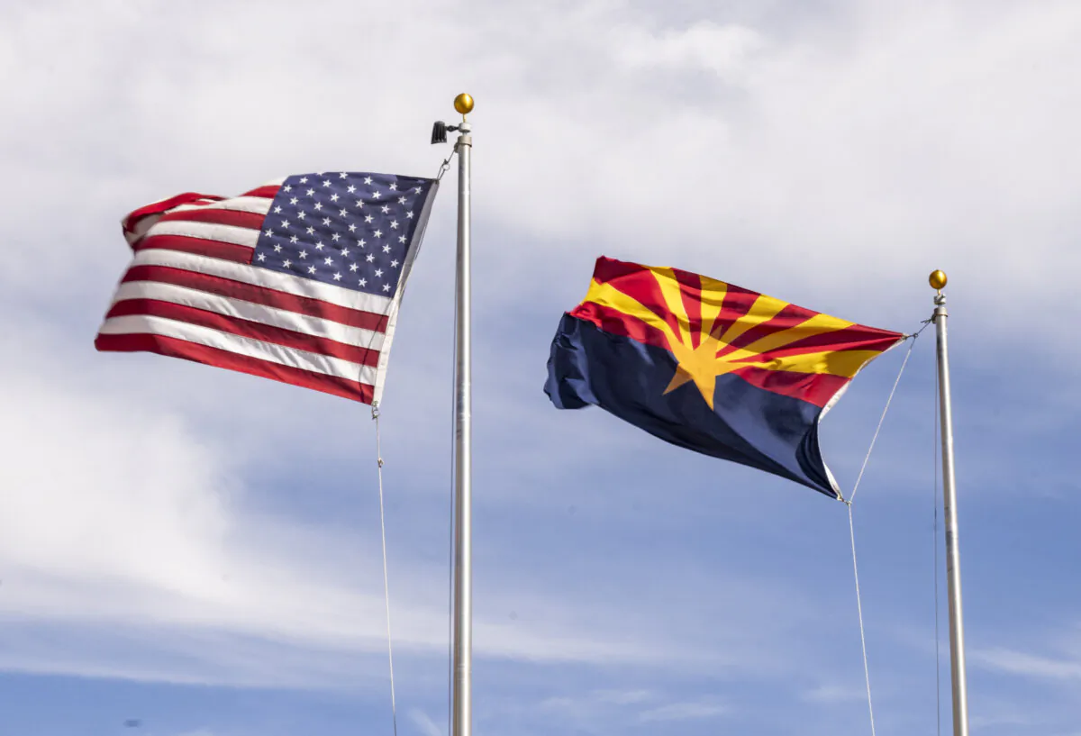 The Arizona and American flags blow in the wind in Terra Vista, Ariz., on March 5, 2025. (John Fredricks/The Epoch Times)