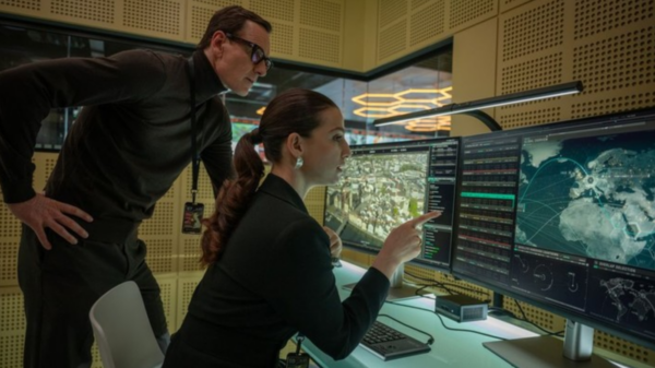 man and woman look at computer in Black Bag