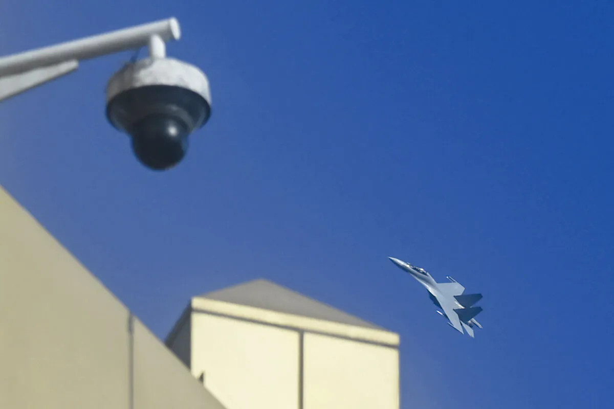 A Chinese jet fighter flies above a closed circuit television (CCTV) camera and buildings on Pingtan Island, the closest point in China to the main island of Taiwan, in China's southeast Fujian Province, on Jan. 13, 2024. (Greg Baker/AFP via Getty Images)