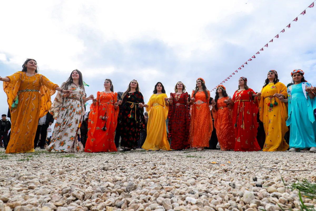 Women dressed in traditional costumes dance during an event organised by NGOs and women's action groups to commemorate International Women's Day in Syria's northeastern city of Qamishli on March 8, 2025. (Delil Souleiman/AFP via Getty Images)