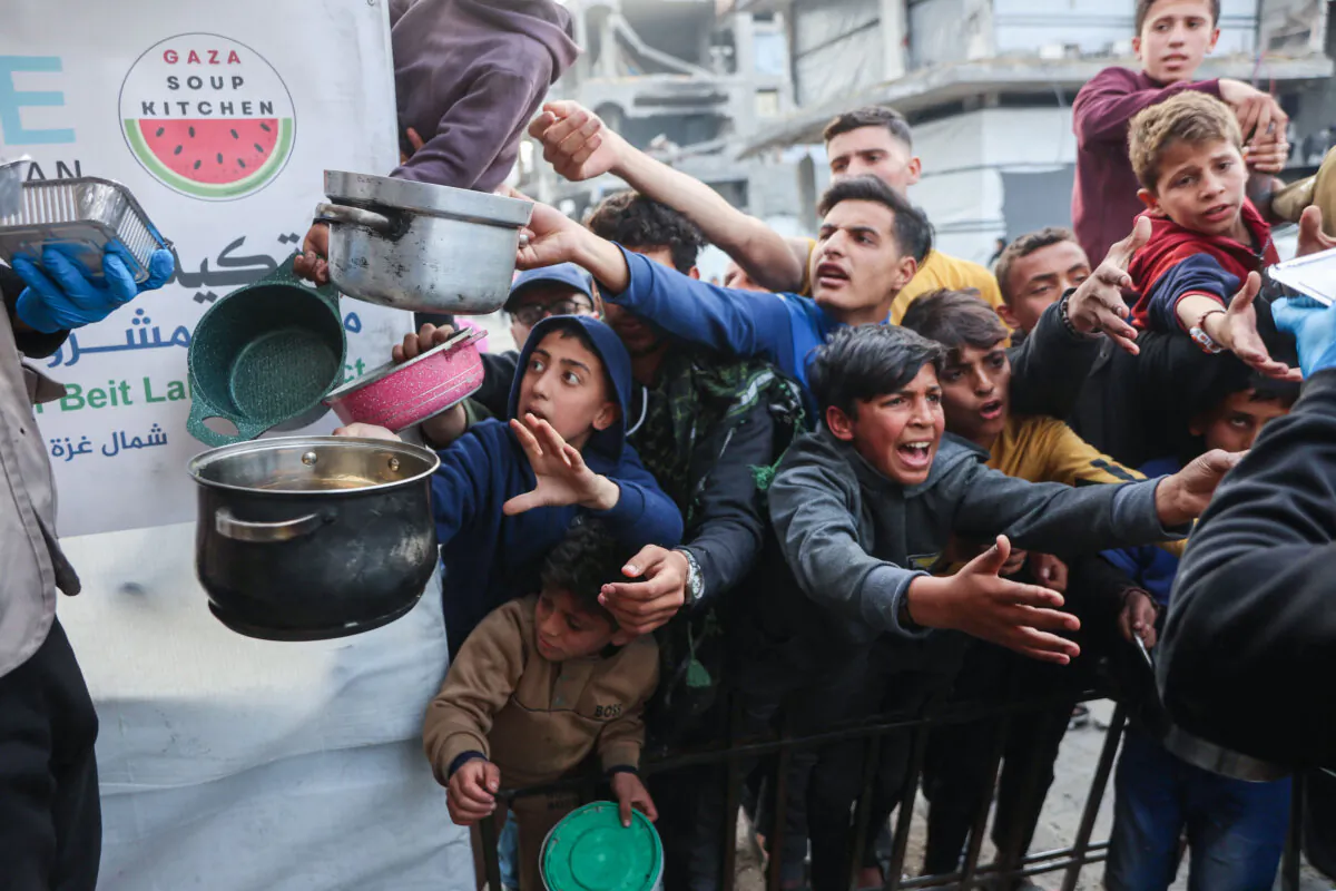 Displaced Palestinian children push into a queue to get a portion of cooked food from a charity kitchen in Beit Lahia in the northern Gaza Strip on March 9, 2025. (Omar al-Qattaa/ AFP via Getty Images)